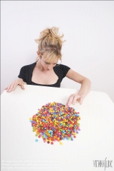 Viennaslide-72000312 Junge Frau vor einer Schale mit Schokolinsen - Young woman in front of bowl with chocolate lentils